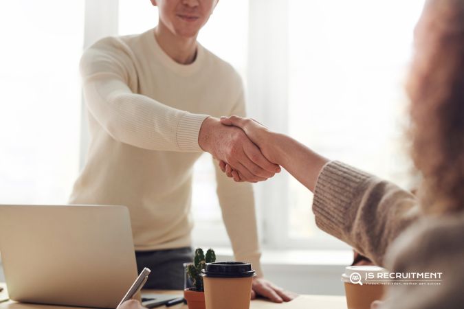 Afbeelding van 2 kantoormensen, die elkaar een hand geven
